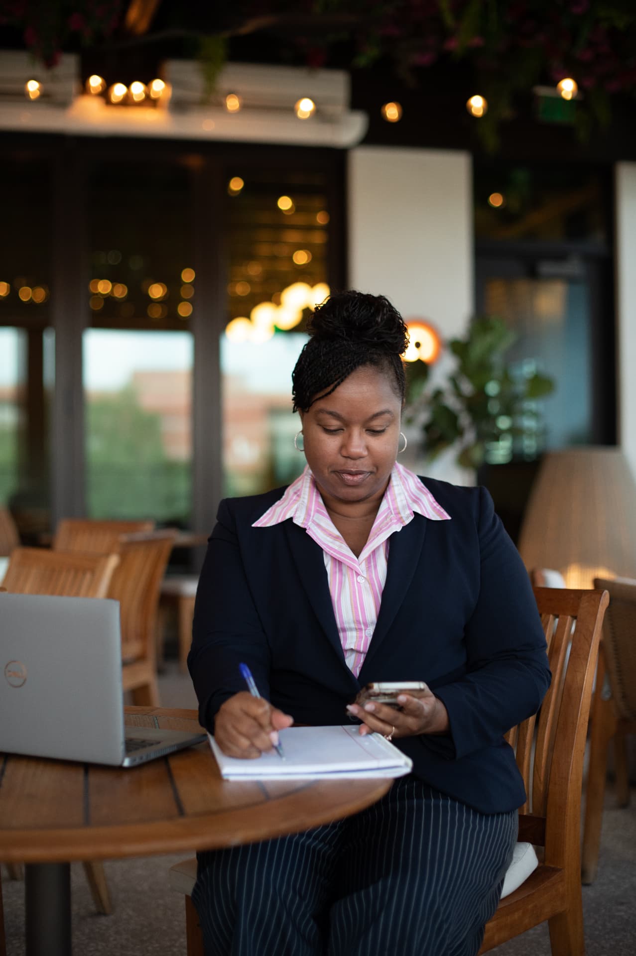 Jennifer Duclair taking notes at a table with a laptop