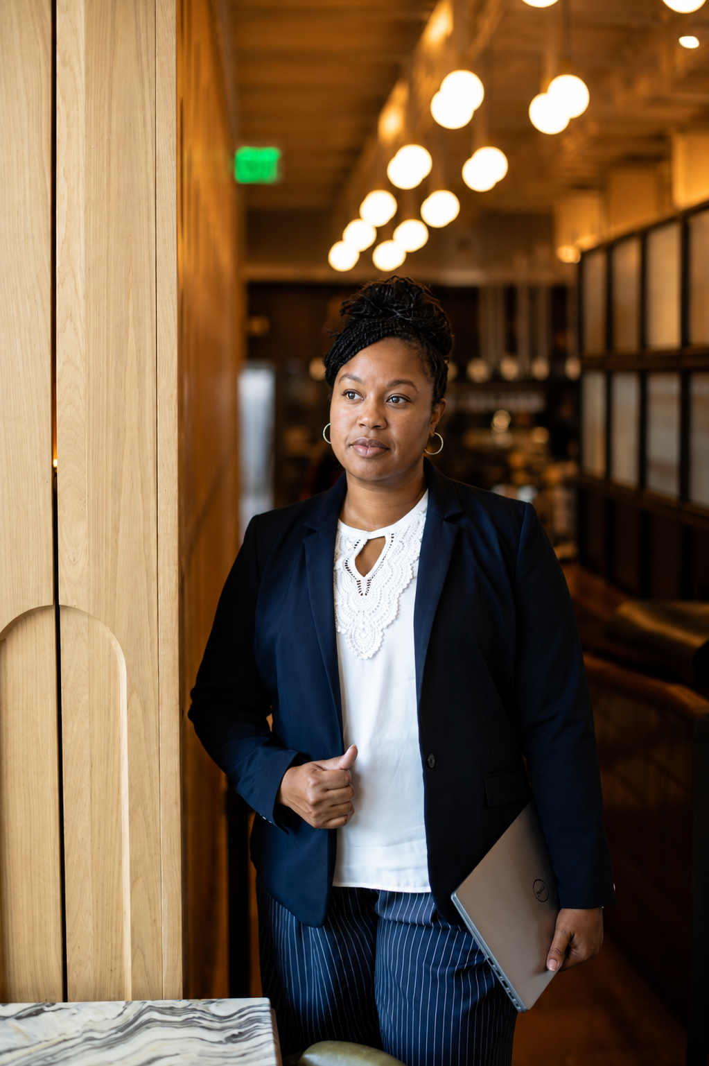 Jennifer Duclair standing with a laptop in a professional setting